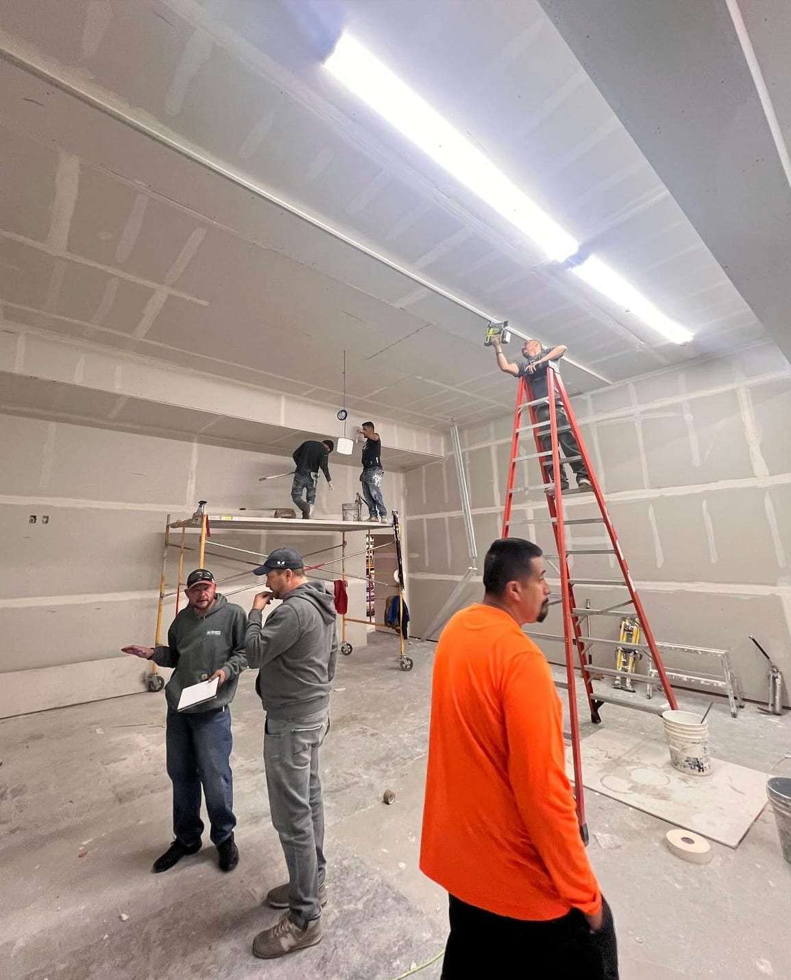 Crew working on drywall in an empty commercial unit